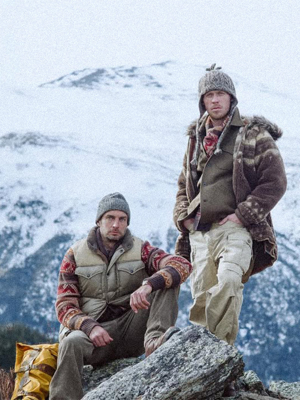 Two people in RRL by Ralph Lauren  winter clothing sitting on a rock with a snowy mountain background